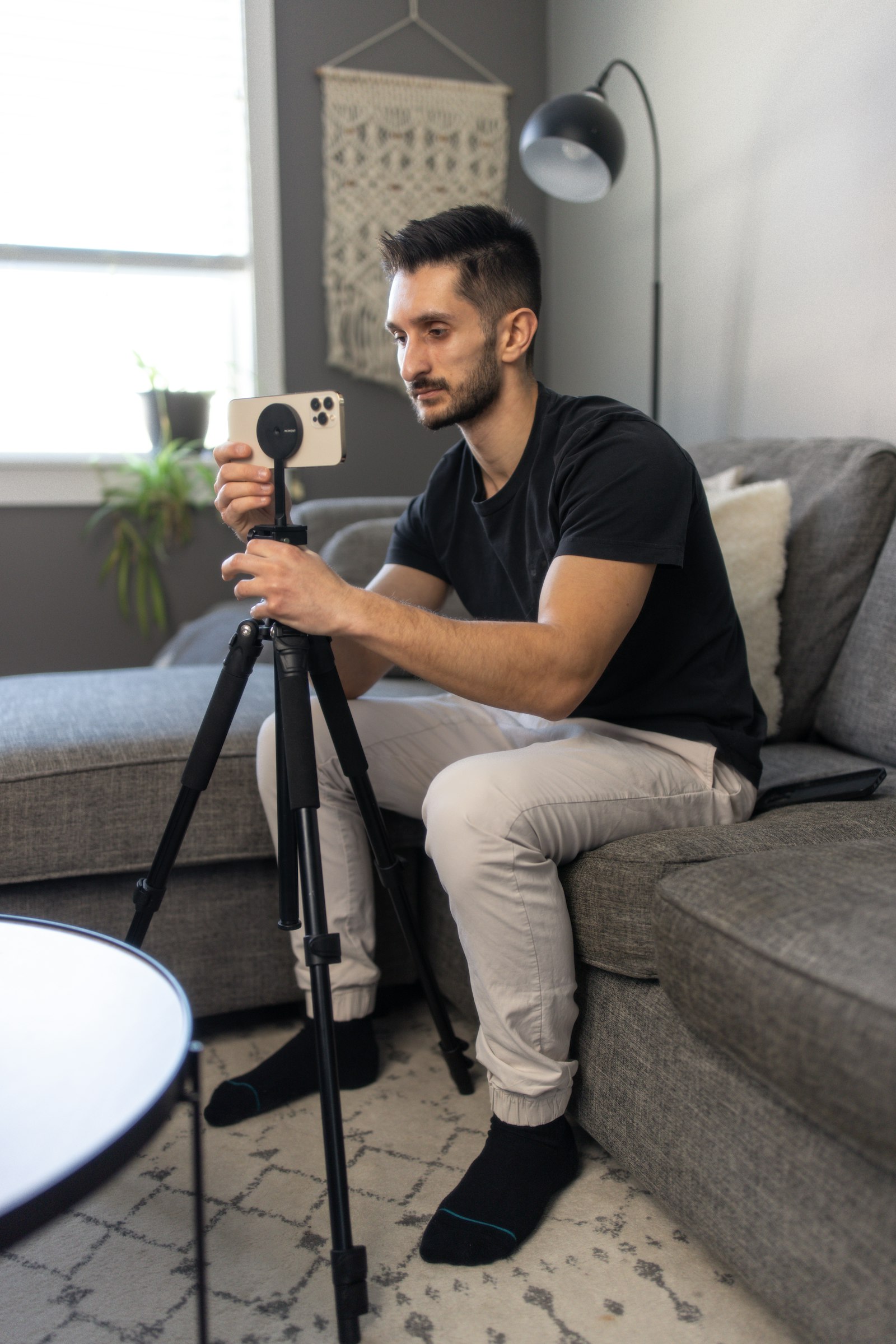 A creator setting up a phone on a tripod at home